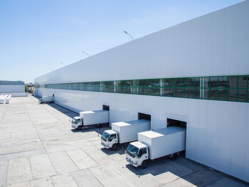 facade of an industrial building and warehouse with freight cars in length