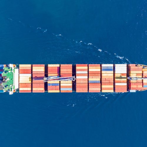 Container cargo ship, import export business and logistics, aerial top view. Water transport, international freight shipping, commercial trade and transportation in the open sea