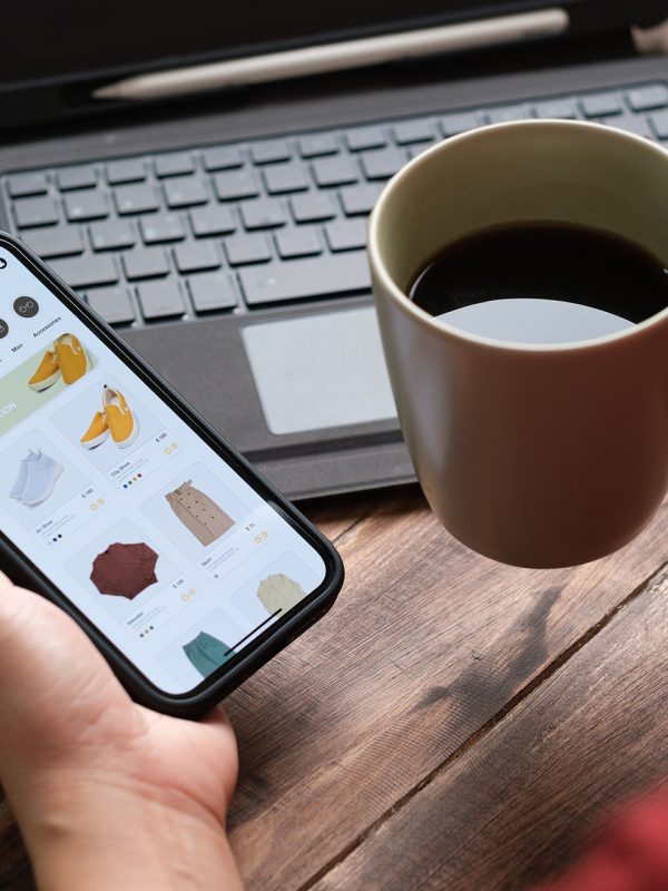 close up woman hand using credit card shopping online on mobile app on wood table at home close up woman hand using credit card shopping online on mobile app on wood table at home